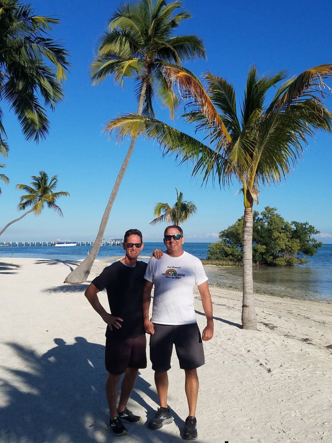 Patrick Fitzgerald and Mark Terrill on a palm-lined beach in the Florida Keys